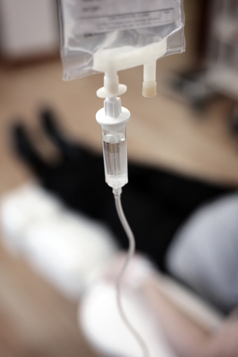 Healthcare professional preparing an energy-boosting IV infusion for a patient